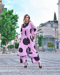Person wearing Anaario Santorini Co-ord Set, pink and white stripe top and pants with black heart print