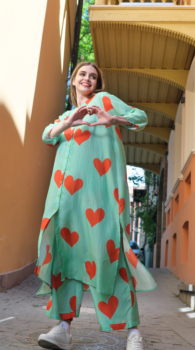 Person wearing Anaario Santorini Co-ord Set, mint green oversized top and pants with orange heart print